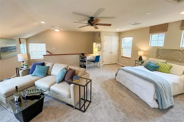 a spacious bedroom with a bed a couch and a chandelier