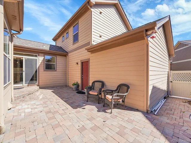 a backyard of a house with table and chairs