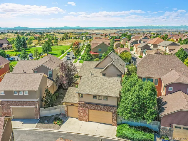 an aerial view of residential houses with outdoor space and ocean view