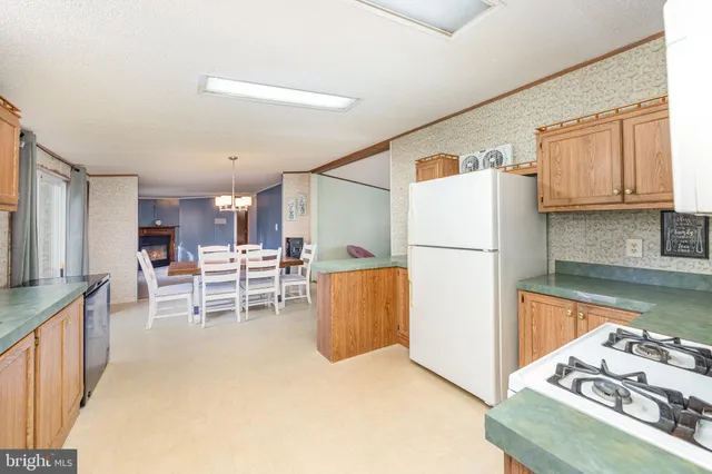 a kitchen with stainless steel appliances granite countertop a refrigerator sink and white cabinets