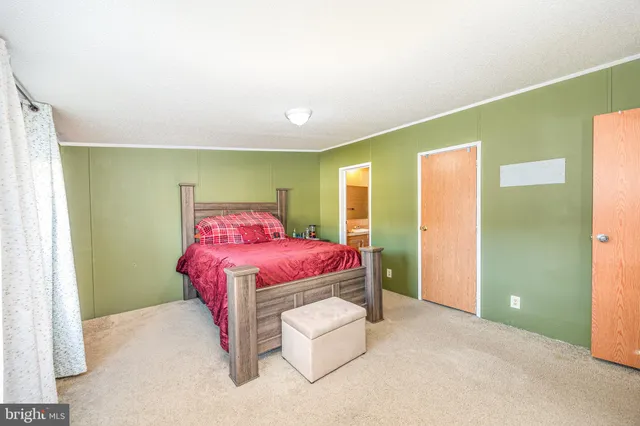 a spacious bedroom with a bed and a chandelier