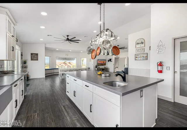 a kitchen with stainless steel appliances granite countertop a sink dishwasher and white cabinets with wooden floor