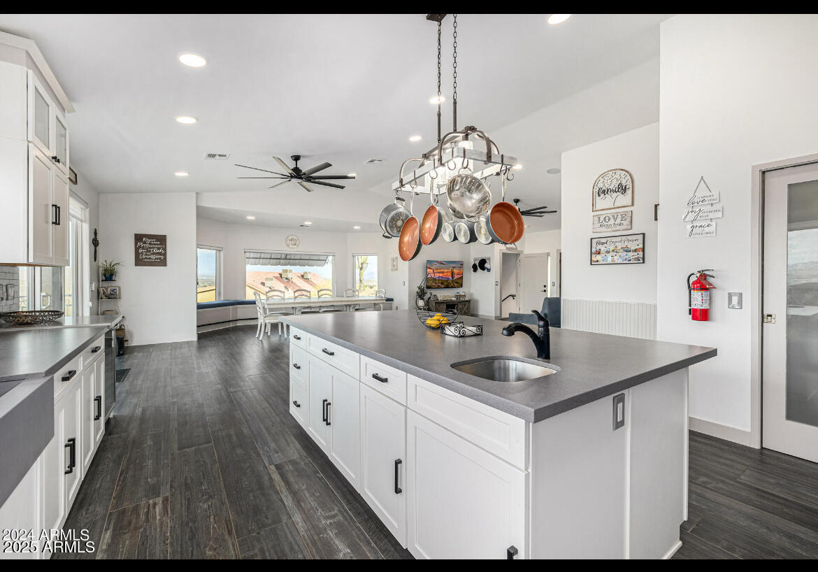 1829 West Cloud Road Phoenix, AZ 85086 - Photo 12 of 18 a kitchen with stainless steel appliances granite countertop a sink dishwasher and white cabinets with wooden floor