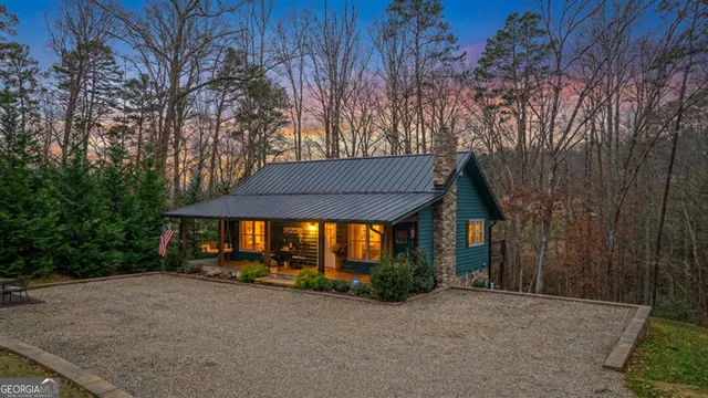 a backyard of a house with wooden fence and large trees