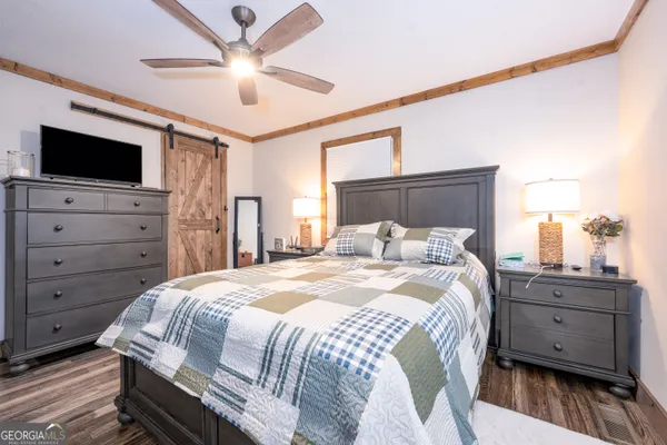 a bedroom with a large bed and flat screen tv