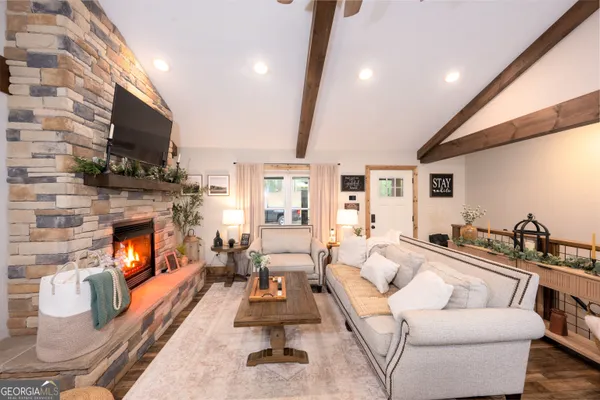 a living room with furniture a fireplace and a flat screen tv