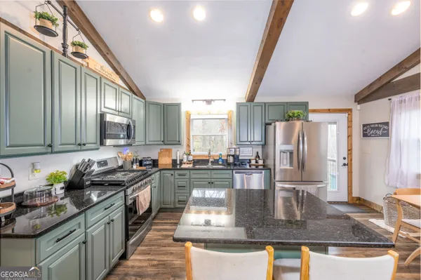 a kitchen with stainless steel appliances granite countertop a sink a stove and a refrigerator