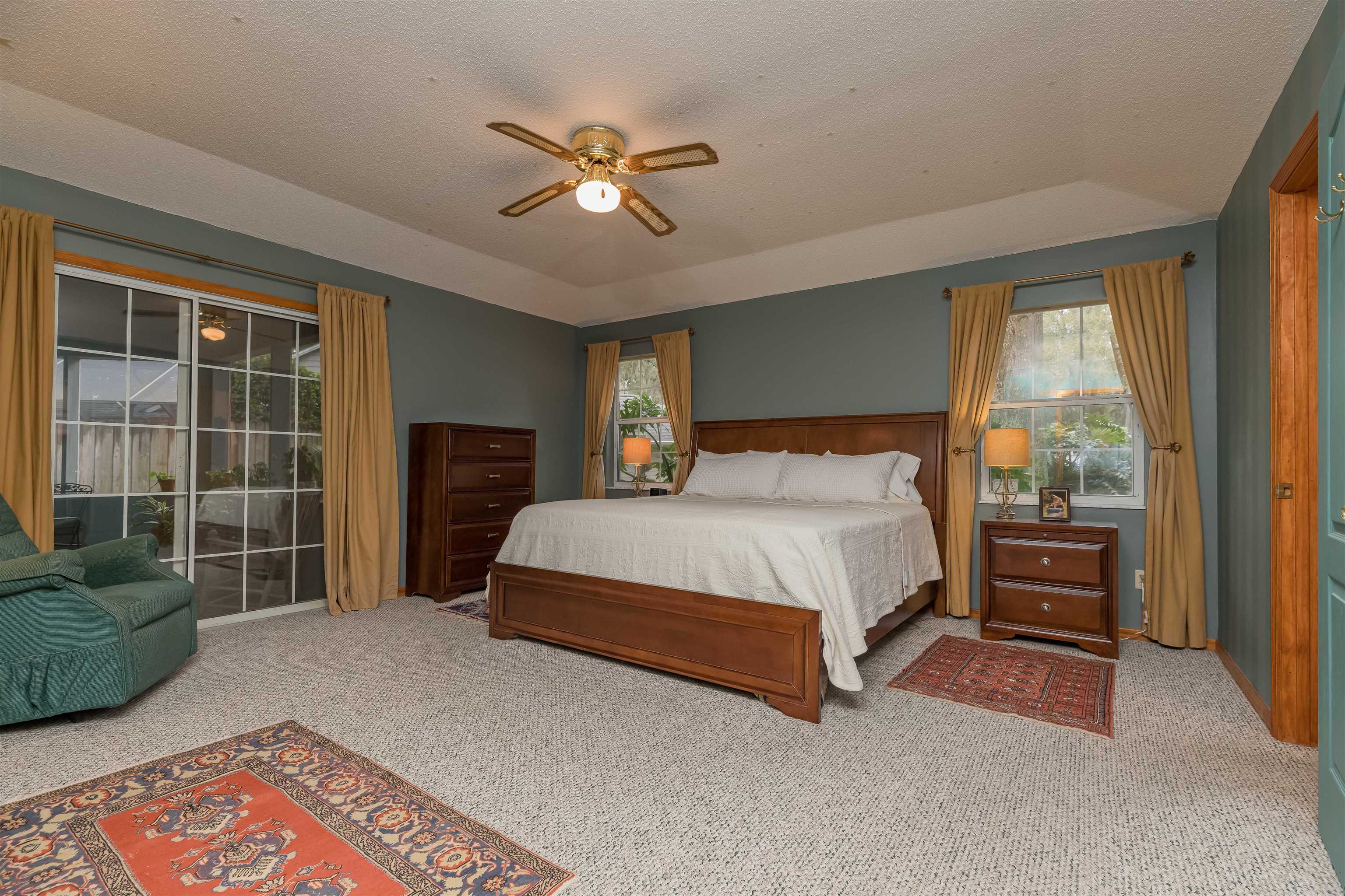 3224 Turtle Creek Road St. Augustine, FL 32086 - Photo 21 of 44 a bed sitting in a spacious bedroom next to a window and a chandelier