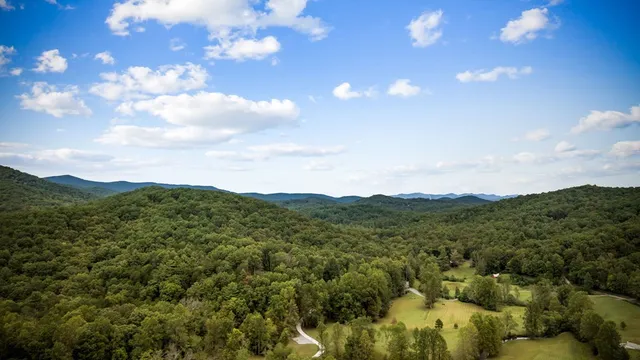 a view of a mountain range with lush green forest