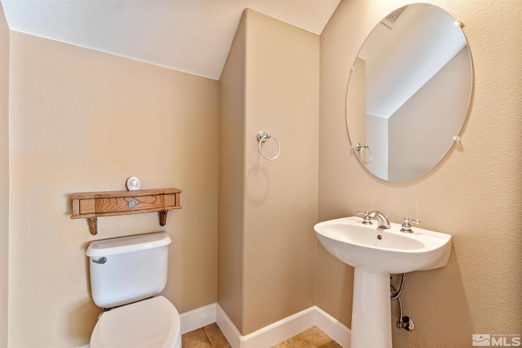 2630 Strathmore Court Reno, NV 89521 - Photo 23 of 40 a bathroom with a toilet sink and mirror
