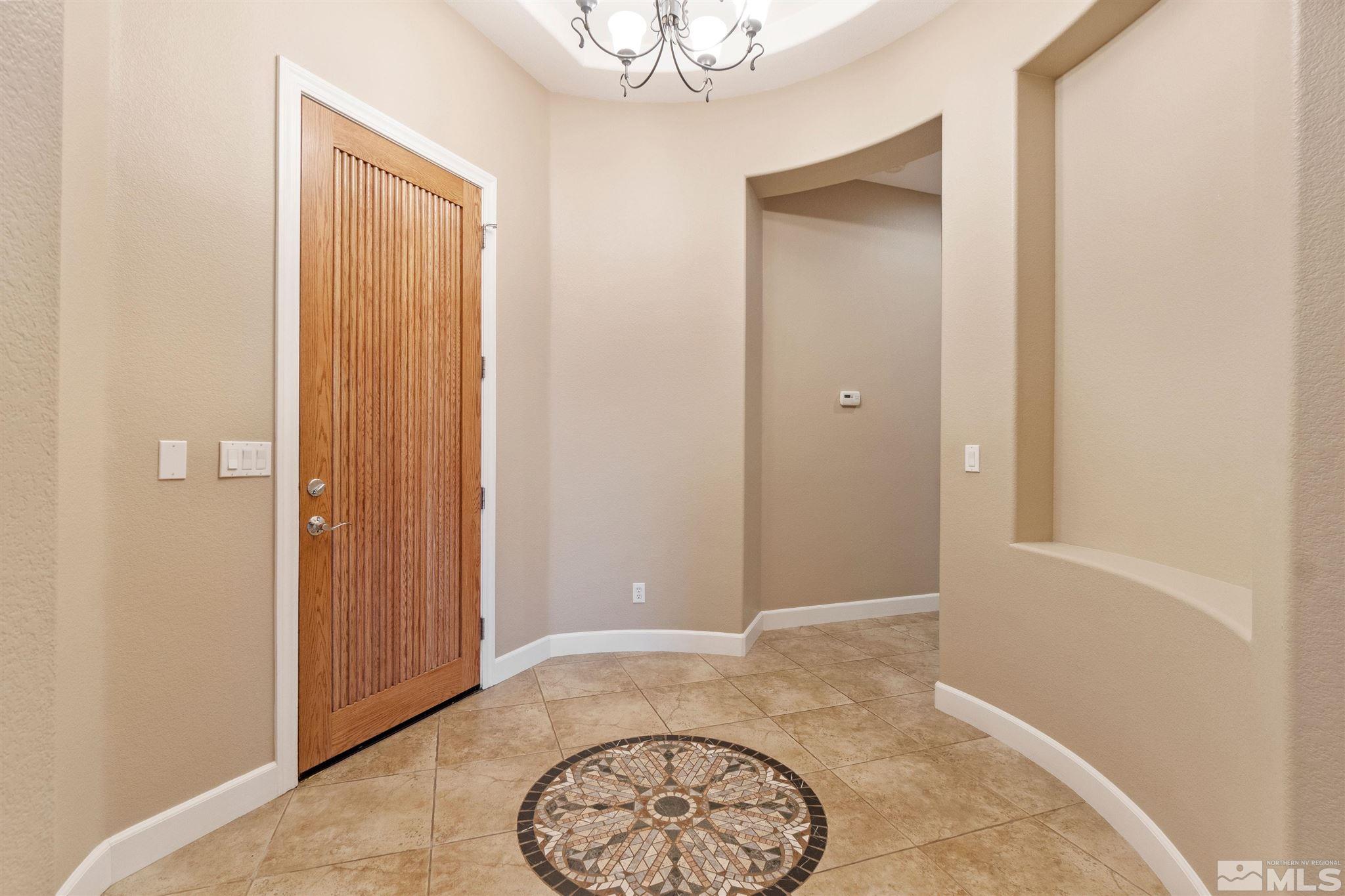 2630 Strathmore Court Reno, NV 89521 - Photo 4 of 40 an empty room with a mirror and a wooden floor