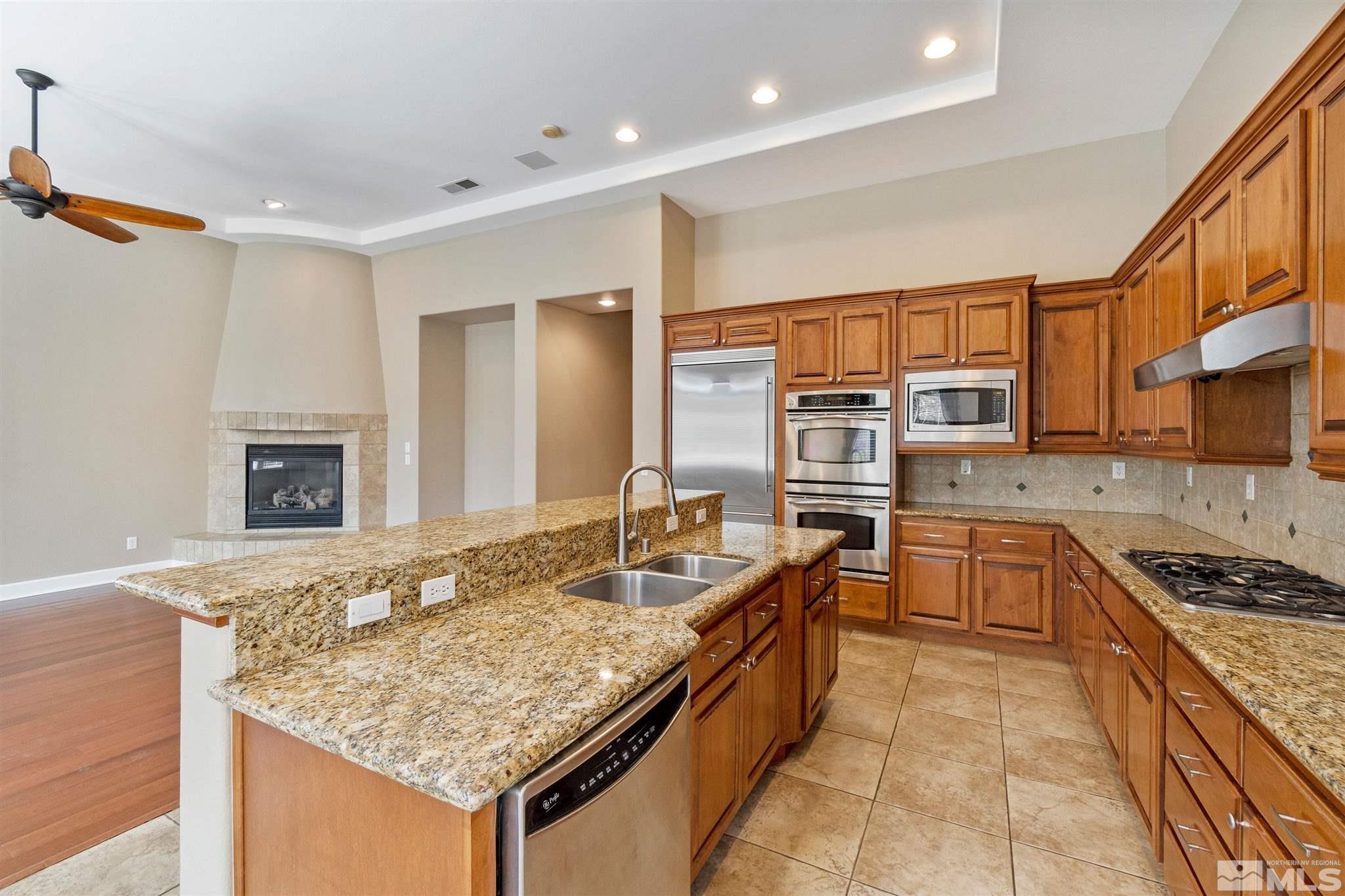 2630 Strathmore Court Reno, NV 89521 - Photo 8 of 40 a kitchen with stainless steel appliances granite countertop a stove sink and cabinets