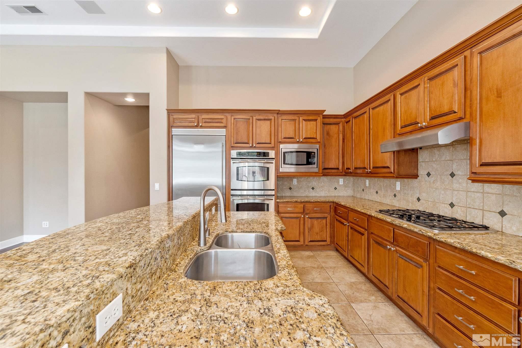 2630 Strathmore Court Reno, NV 89521 - Photo 9 of 40 a kitchen with stainless steel appliances granite countertop a sink stove and cabinets