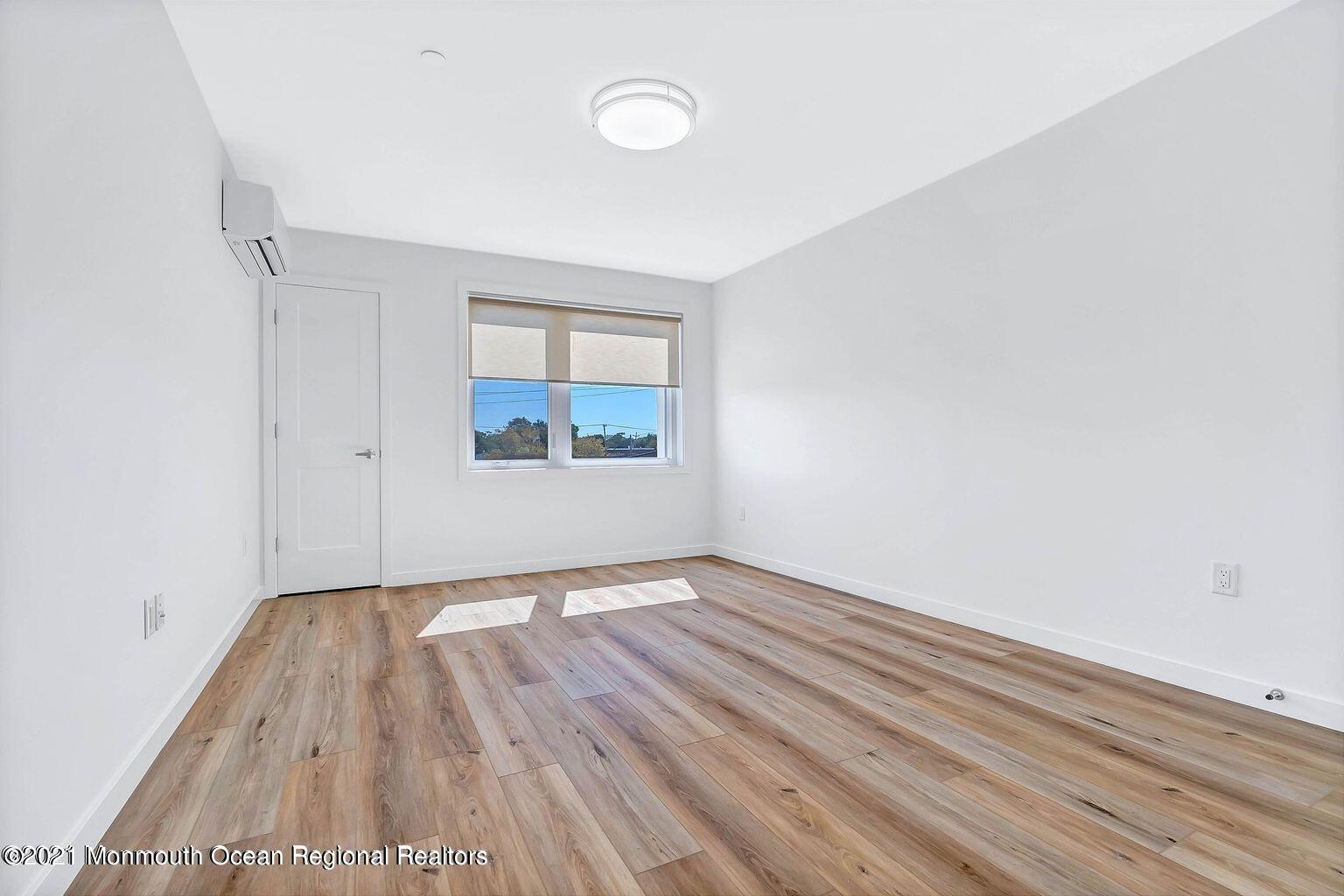 131 Brighton Avenue, Unit 208 Long Branch, NJ 07740 - Photo 20 of 30 an empty room with wooden floor and windows