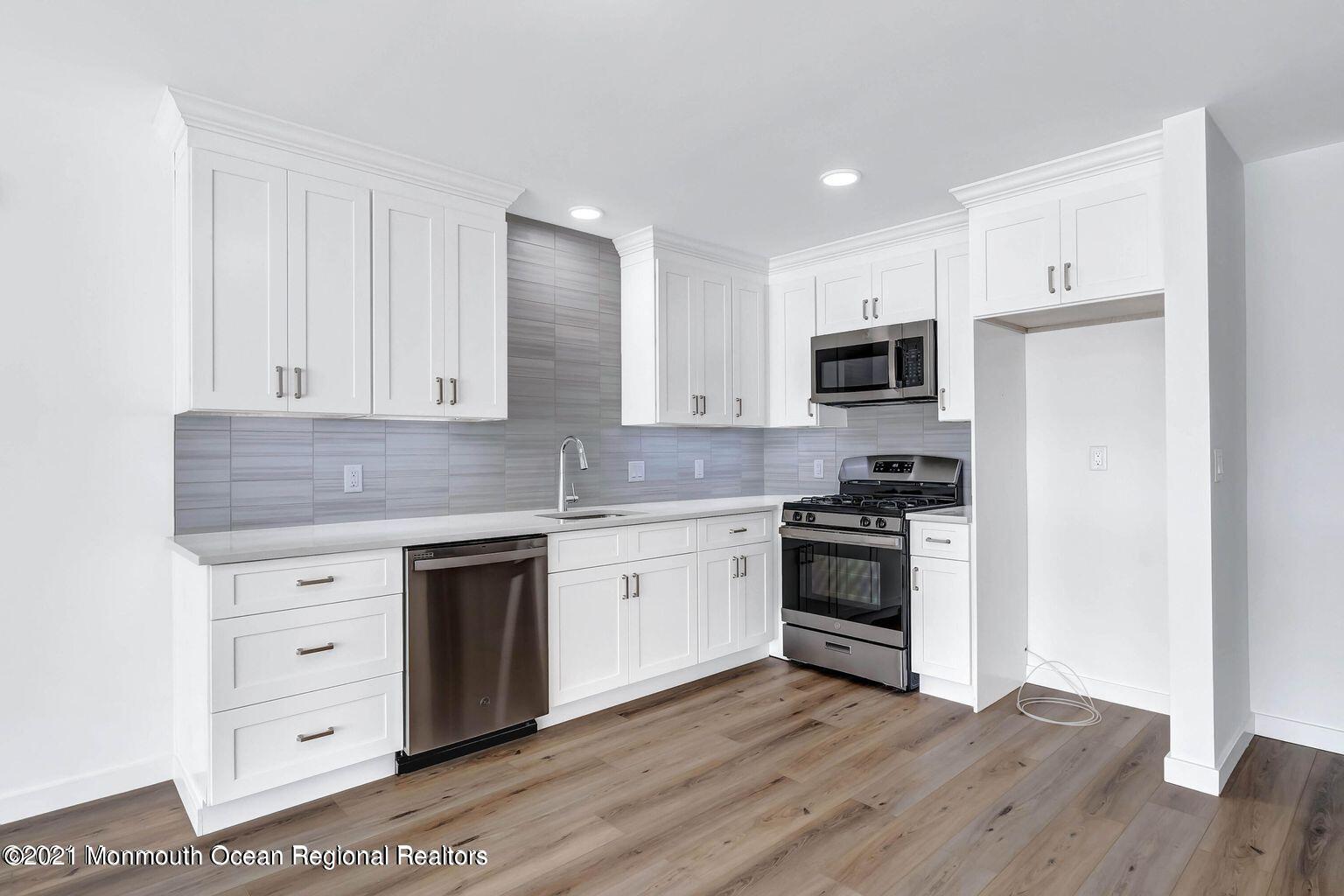 131 Brighton Avenue, Unit 208 Long Branch, NJ 07740 - Photo 4 of 30 a kitchen with granite countertop white cabinets and stainless steel appliances