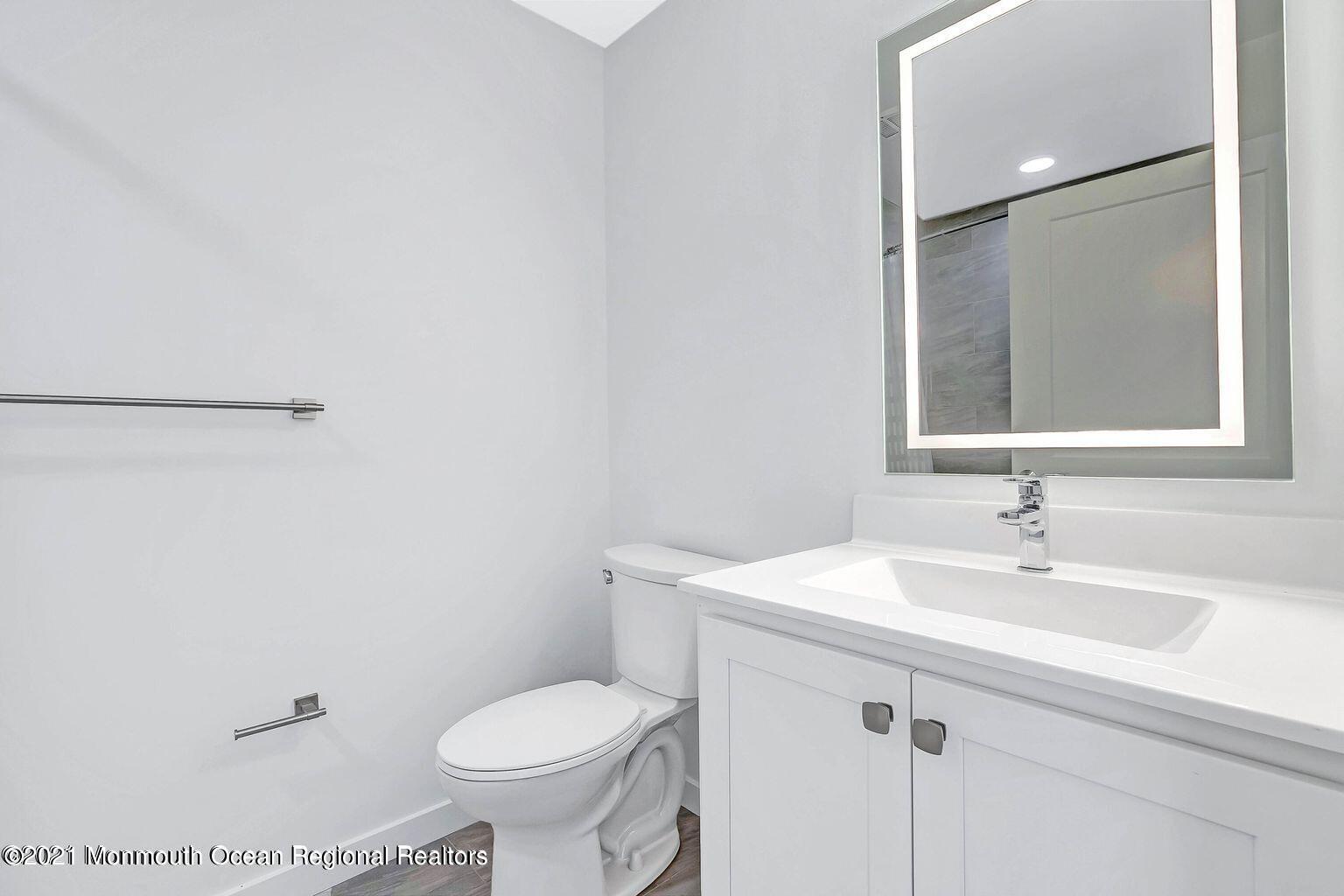 131 Brighton Avenue, Unit 208 Long Branch, NJ 07740 - Photo 9 of 30 a bathroom with a sink toilet and a mirror