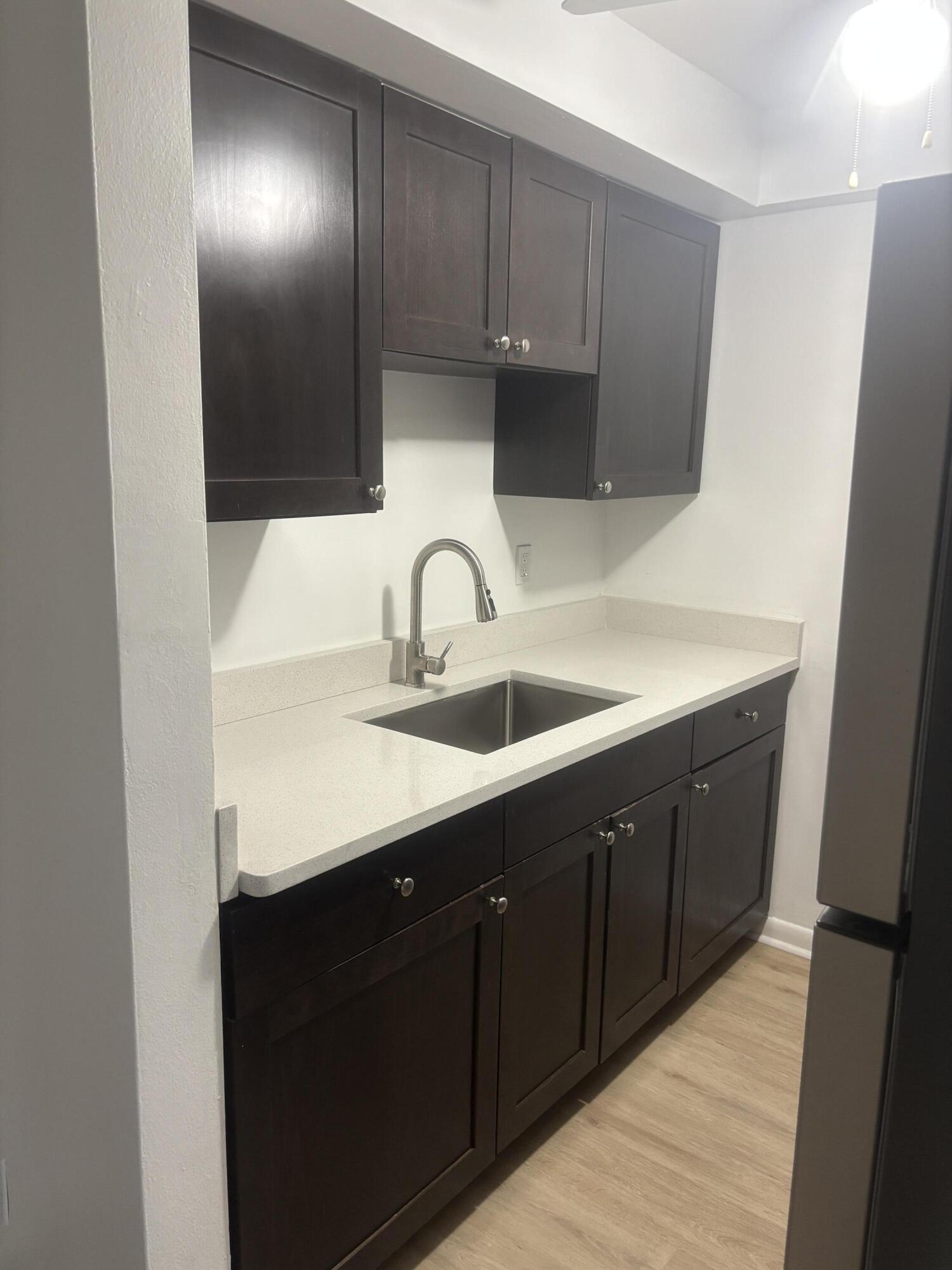 521 Northeast 45th Street Boca Raton, FL 33431 - Photo 8 of 17 a kitchen with wooden cabinets a sink and a stove
