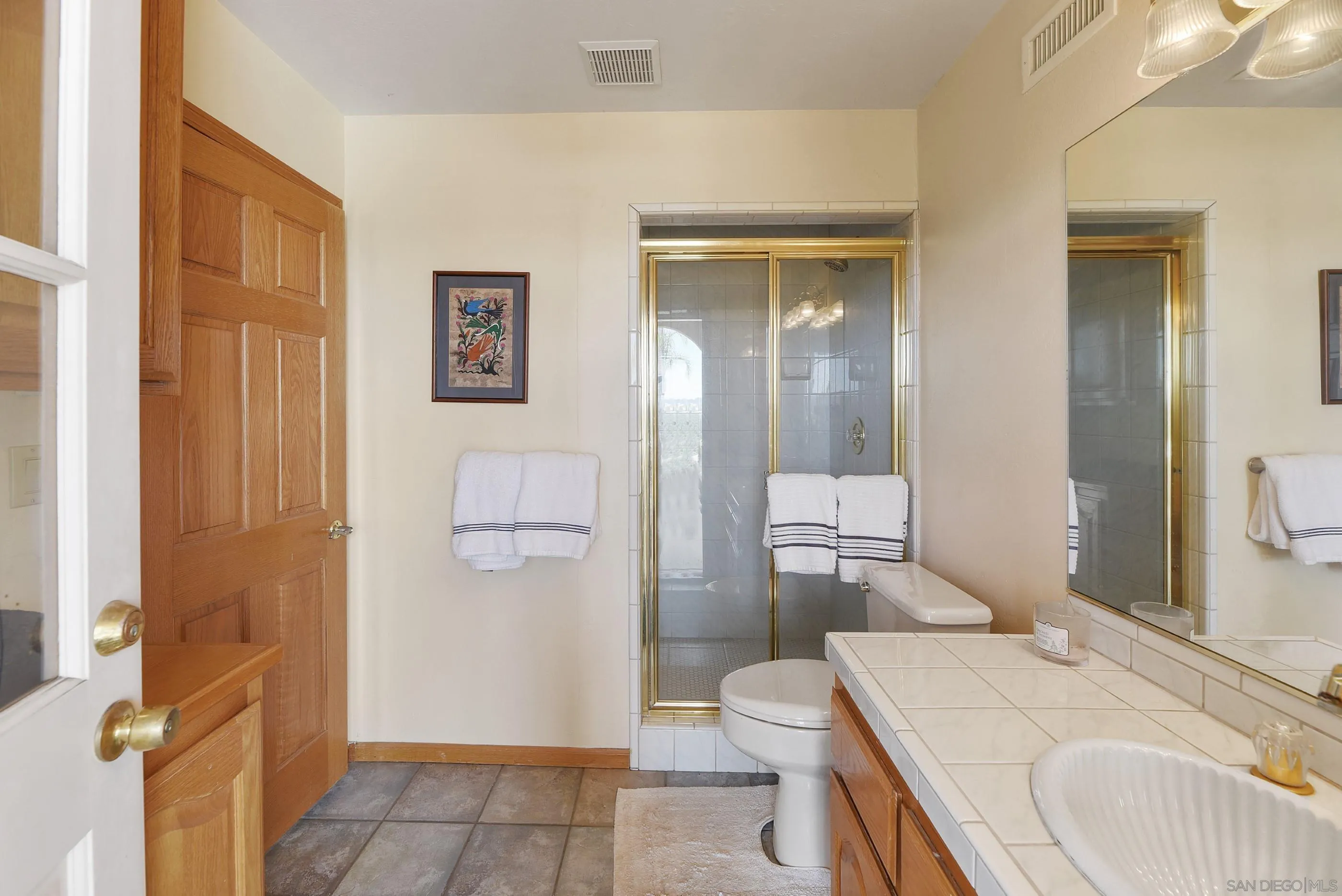 12963 Glen Circle Road Poway, CA 92064 - Photo 55 of 75 a bathroom with a granite countertop sink a toilet and shower