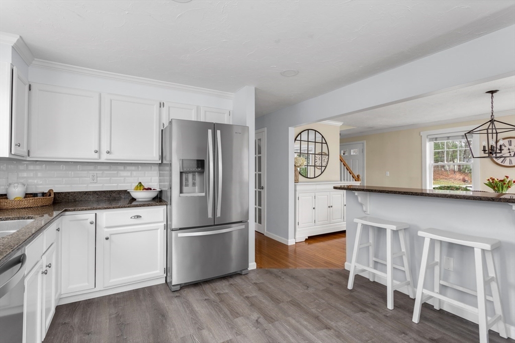 7 Glenwood Road Franklin, MA 02038 - Photo 9 of 46 a kitchen with granite countertop a refrigerator a sink dishwasher and white cabinets with wooden floor