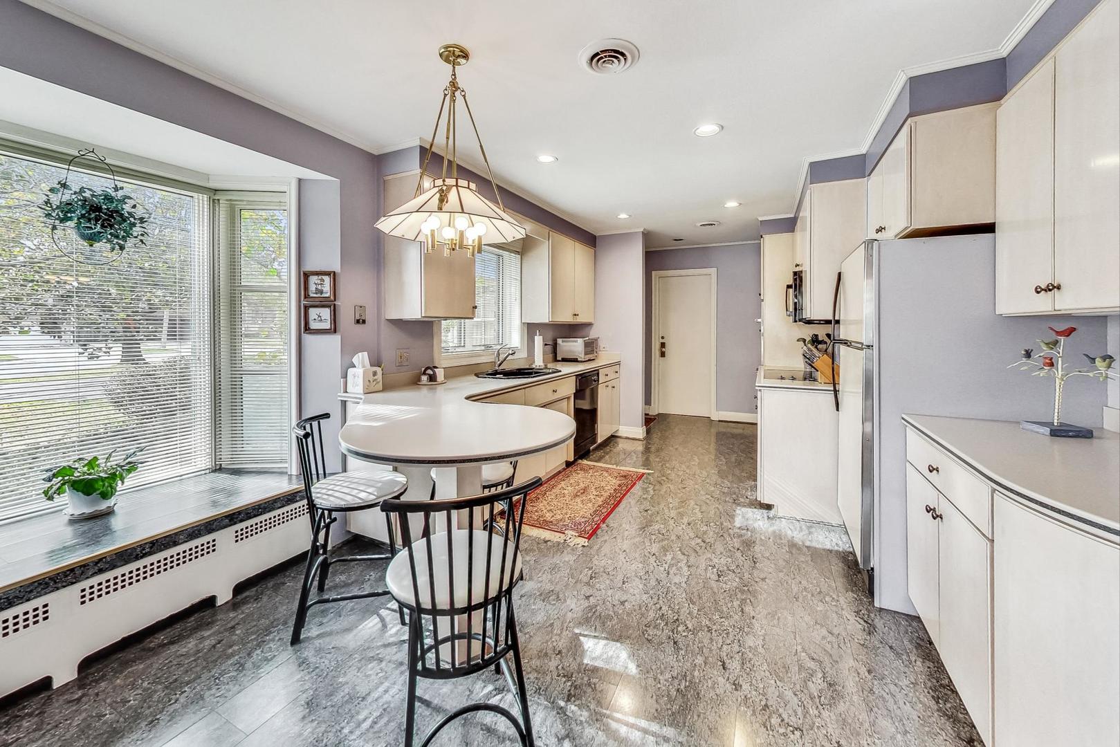 701 East Avenue Park Ridge, IL 60068 - Photo 14 of 37 a kitchen with sink a refrigerator and chairs