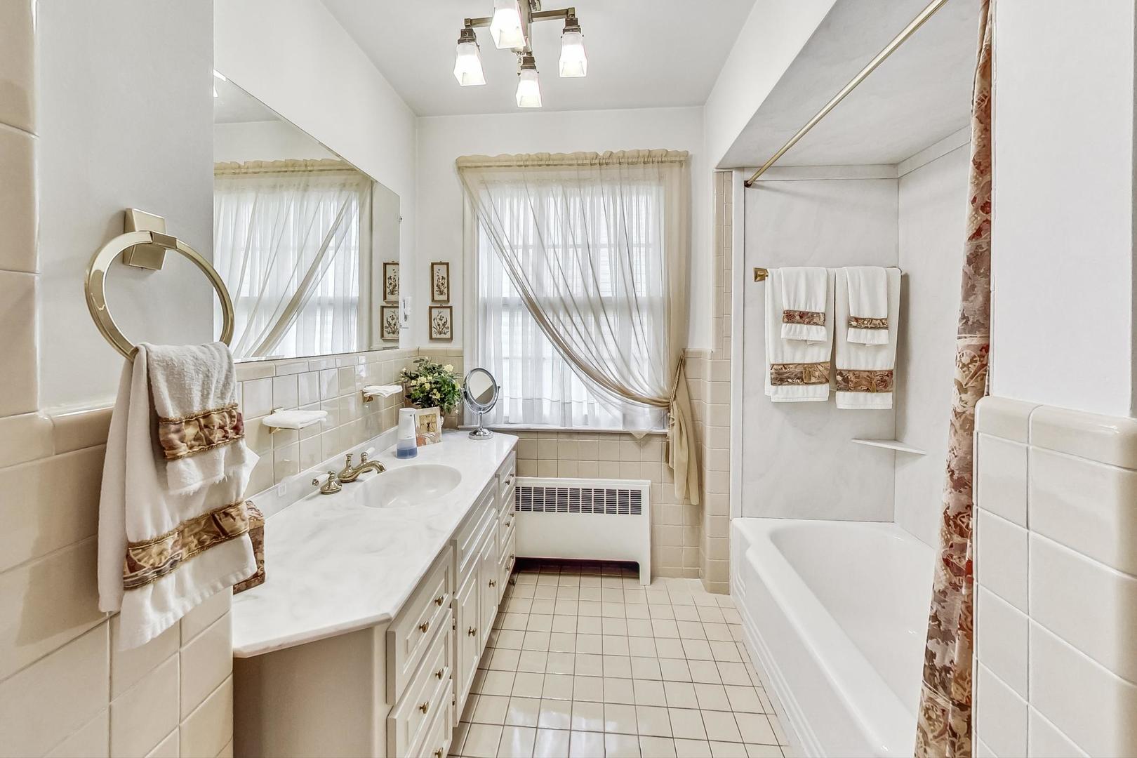 701 East Avenue Park Ridge, IL 60068 - Photo 23 of 37 a bathroom with a sink tub vanity and a mirror