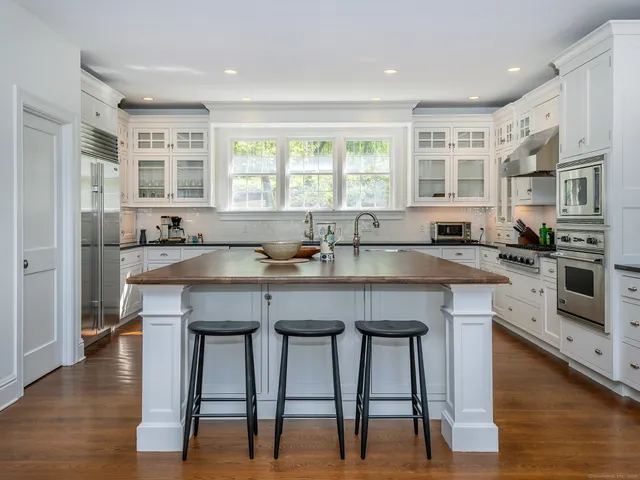 a kitchen with granite countertop a table chairs stove and cabinets
