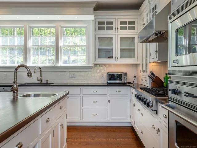 a kitchen with cabinets appliances and a window