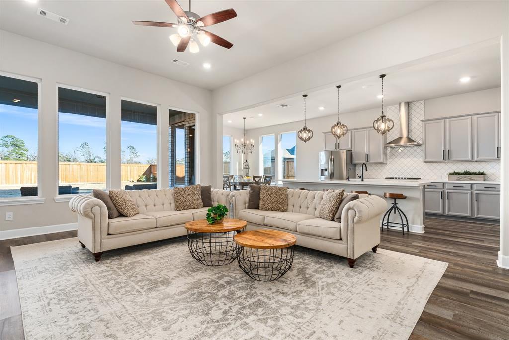 a living room with furniture kitchen view and a chandelier