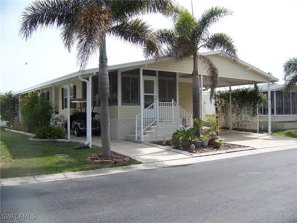 a view of a house with a yard and potted plants