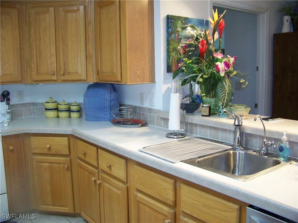 15550 Burnt Store Road, Unit 128 Punta Gorda, FL 33955 - Photo 16 of 50 a kitchen with stainless steel appliances granite countertop a sink a cabinetry and potted plant