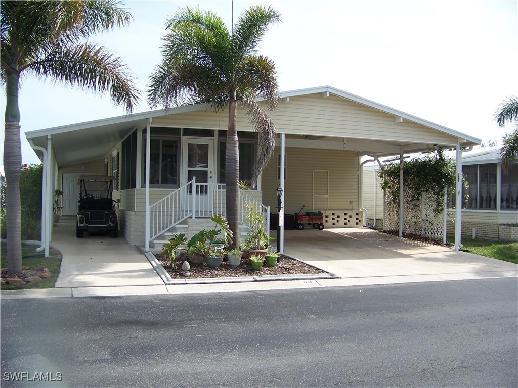 15550 Burnt Store Road, Unit 128 Punta Gorda, FL 33955 - Photo 2 of 50 a front view of a house with yard and garage