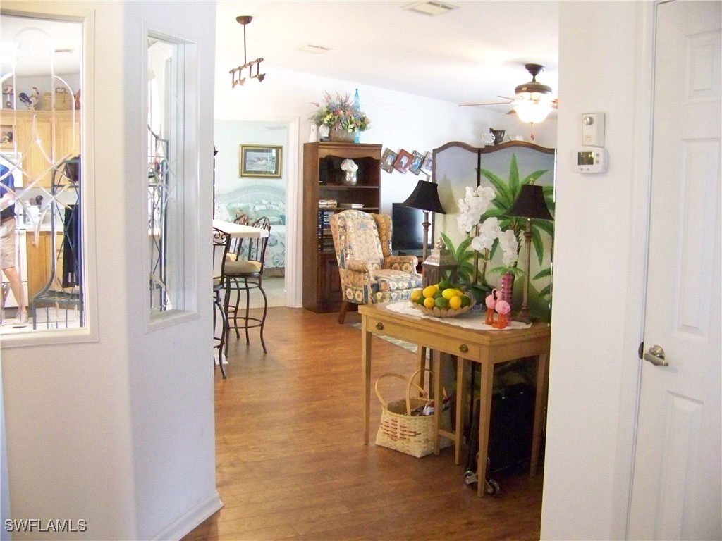 15550 Burnt Store Road, Unit 128 Punta Gorda, FL 33955 - Photo 22 of 50 a hallway with dining room and chandelier