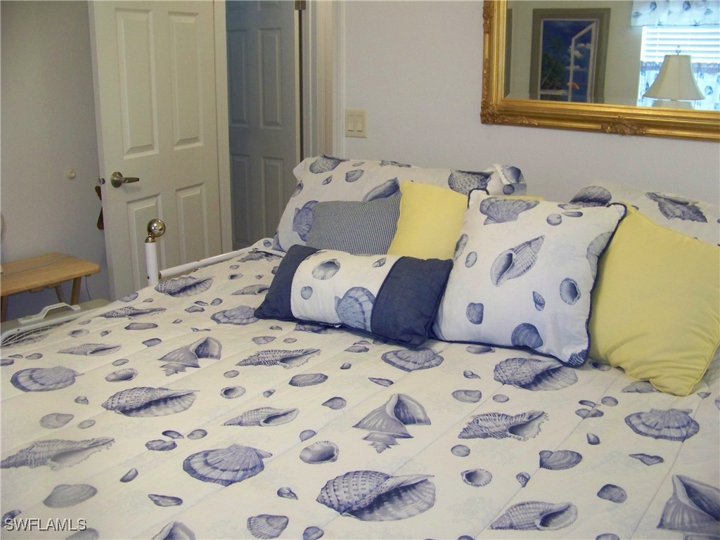 15550 Burnt Store Road, Unit 128 Punta Gorda, FL 33955 - Photo 34 of 50 a large bed sitting in a bedroom next to a window and a lamp