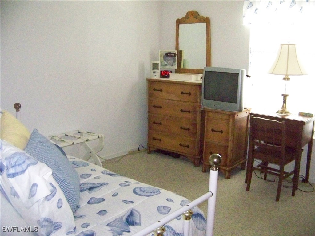 15550 Burnt Store Road, Unit 128 Punta Gorda, FL 33955 - Photo 35 of 50 a bedroom with a bed and chair