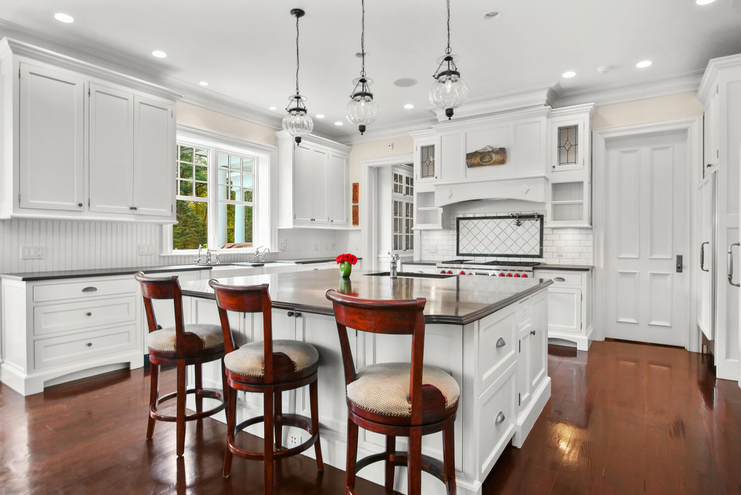 363 West Road New Canaan, CT 06840 - Photo 20 of 68 an open kitchen with granite countertop a stove a sink a dining table and chairs with wooden floor