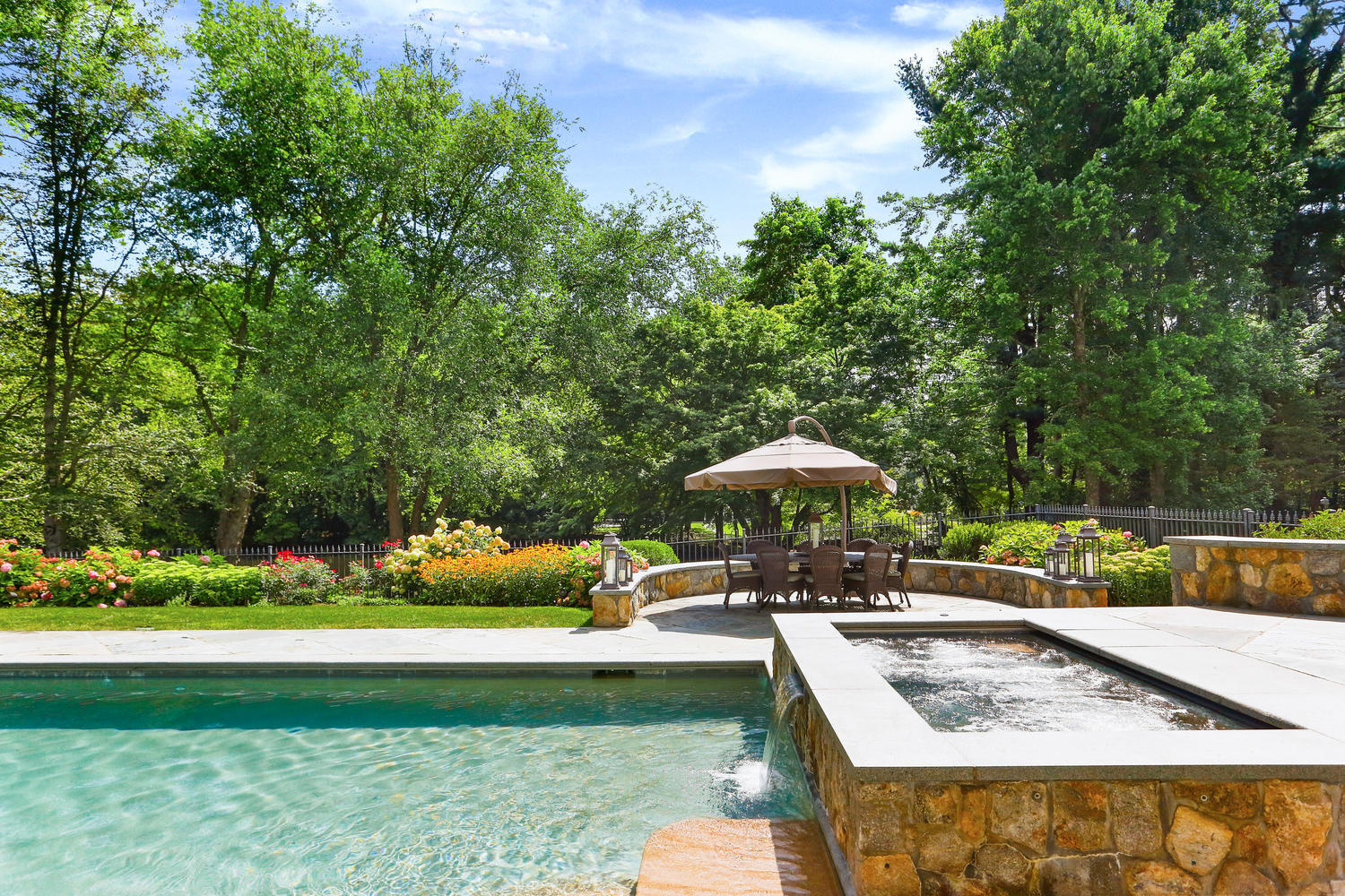 363 West Road New Canaan, CT 06840 - Photo 53 of 68 a view of a swimming pool with lawn chairs under an umbrella