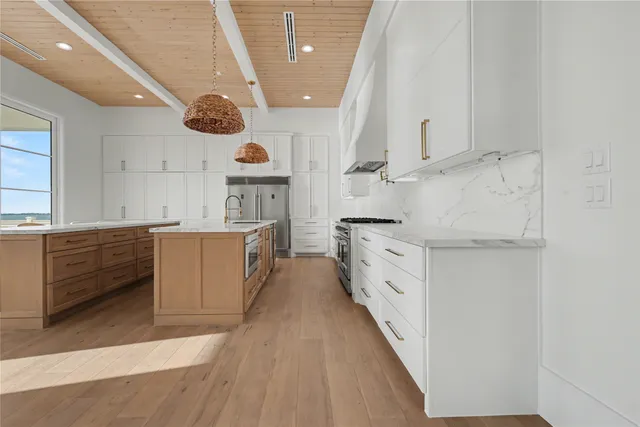 a large white kitchen with cabinets and a large window