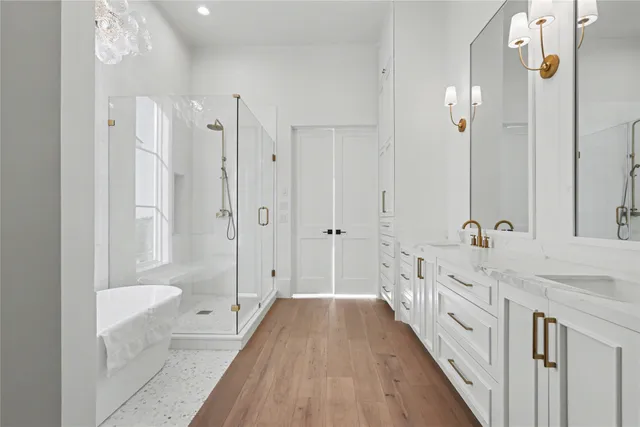 a spacious bathroom with a double vanity sink a large mirror a bathtub and shower