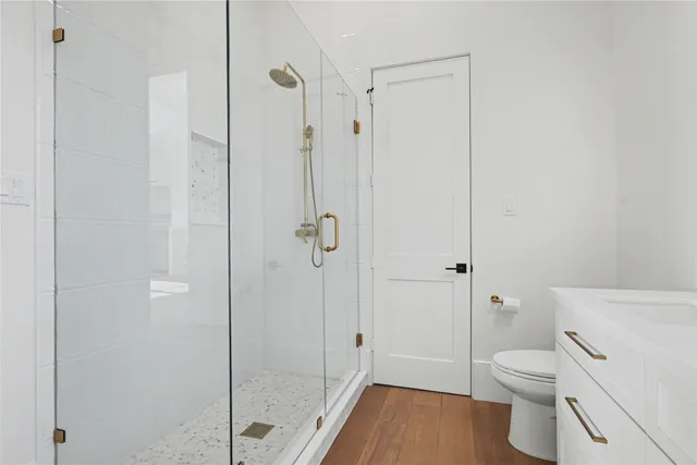 a bathroom with a granite countertop toilet a sink and shower