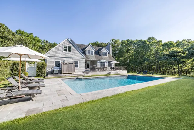 a view of a house with swimming pool and sitting area