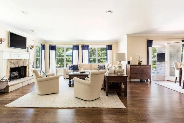 a living room with furniture a flat screen tv and a fireplace