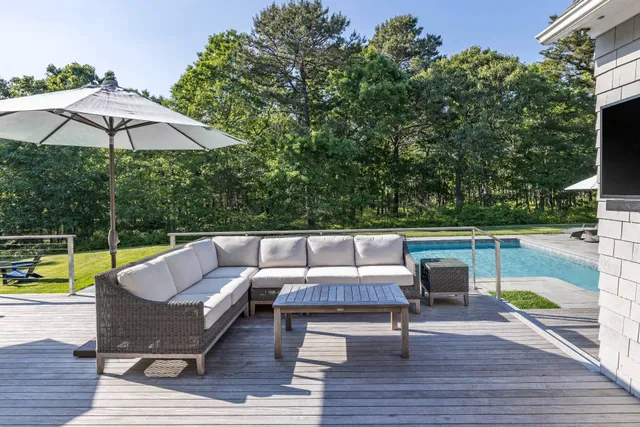 an outdoor sitting area with furniture and wooden floor