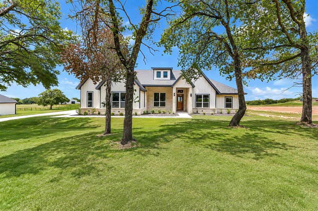 1057 Vh Ranch Poolville, TX 76487 - Photo 4 of 38 a front view of a house with a yard