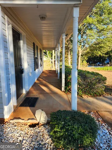 a view of a porch with a floor to ceiling window and wooden fence
