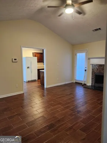 a view of empty room with wooden floor and fireplace