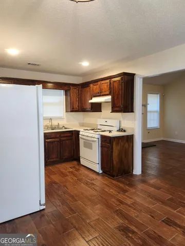 a kitchen with stainless steel appliances a stove top oven a sink dishwasher and a refrigerator