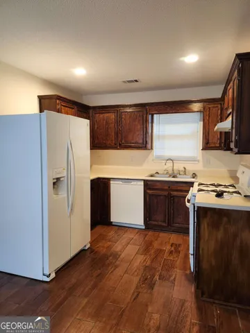 a kitchen with a refrigerator and a stove top oven