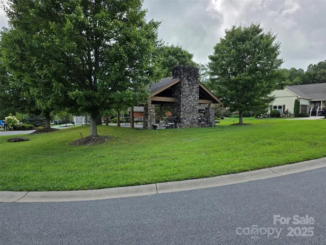 a view of a house with a big yard and large trees