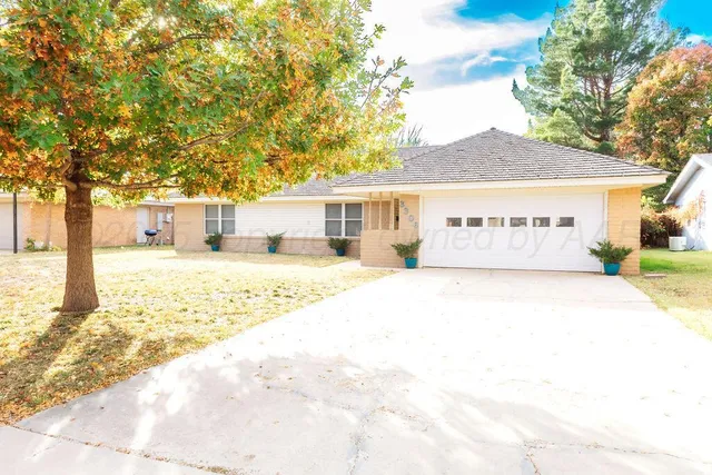 a front view of a building with large trees