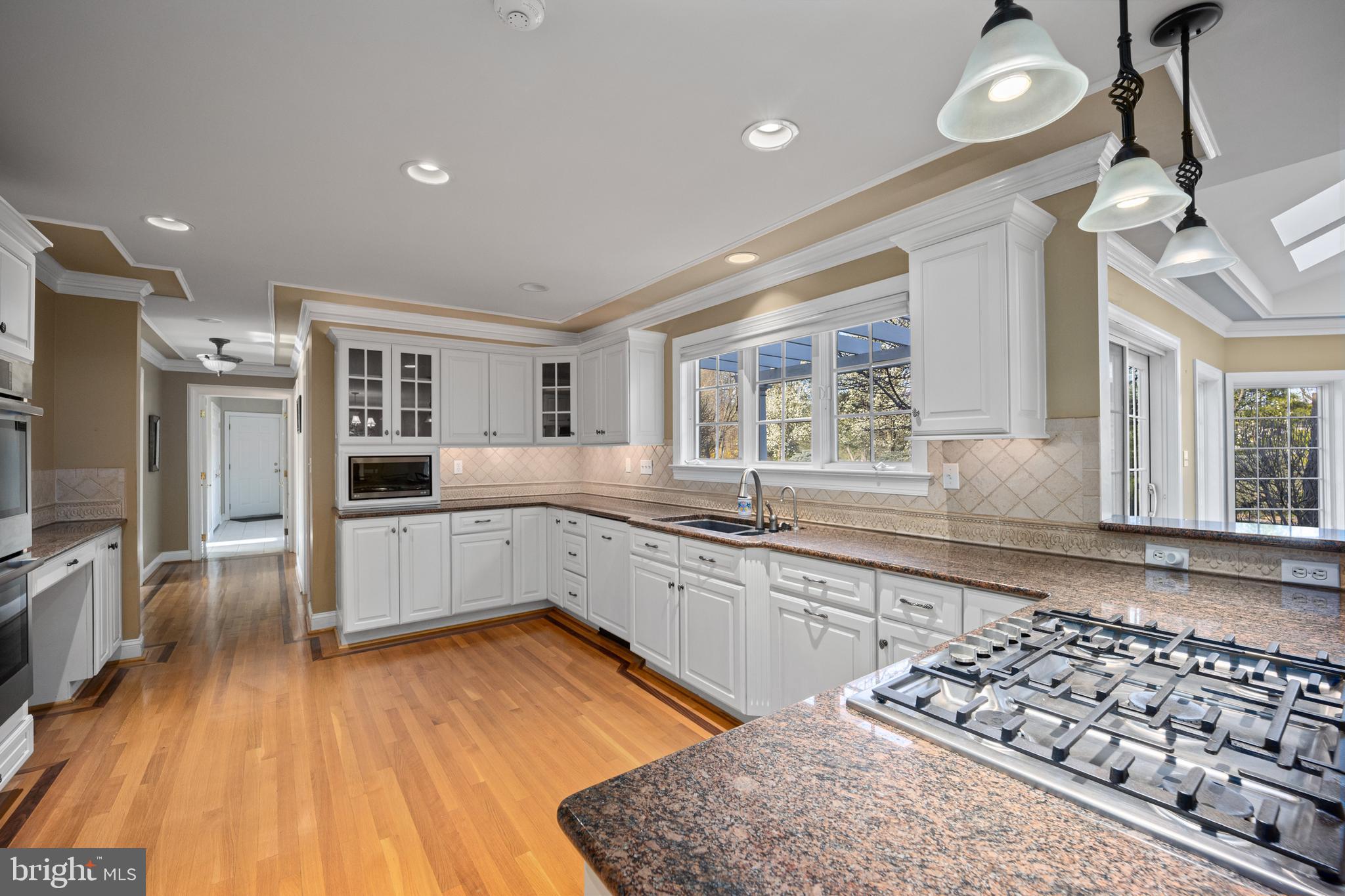 734 Northbrook Road Kennett Square, PA 19348 - Photo 25 of 89 a kitchen with stainless steel appliances kitchen island granite countertop a stove a sink and white cabinets with wooden floor